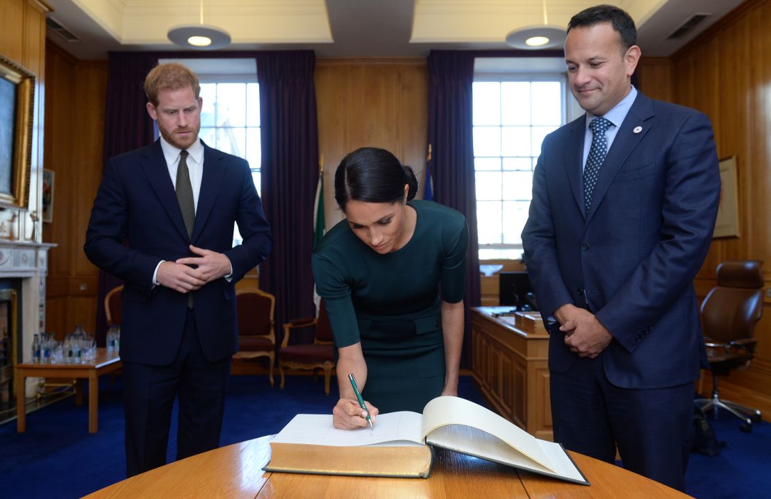 Harry and Meghan sign the visitors book in the Prime Minister's Office.