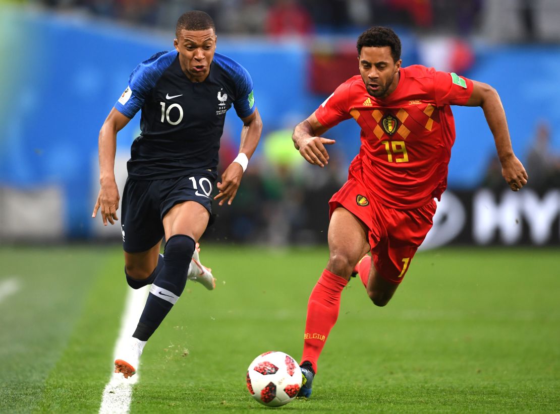 Kylian Mbappe of France runs with the ball under pressure from Moussa Dembele of Belgium.