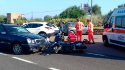 Ambulance personnel tend to a man lying on the ground, later identified as actor George Clooney, after being involved in a scooter accident near Olbia, on the Sardinia island, Italy, Tuesday, July 10, 2018. Actor George Clooney was taken to the hospital in Sardinia on Tuesday and released after being involved in an accident while riding his motor scooter, hospital officials said. "He is recovering at his home and will be fine," spokesman Stan Rosenfield told The Associated Press in an email. The John Paul II hospital in Olbia confirmed Clooney had been treated and released after Tuesday's accident. Local media that had gathered at the hospital said Clooney left in a van through a side exit. (AP Photo/Mario Chironi)