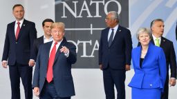 US President Donald Trump (3L) gestures as he poses alongside Britain's Prime Minister Theresa May (2R) as Portugal's Prime Minister Antonio Costa (C) and Greek Prime Minister Alexis Tsipras (2L) look on during the opening ceremony of the NATO (North Atlantic Treaty Organization) summit, at the NATO headquarters in Brussels, on July 11, 2018. (Photo by EMMANUEL DUNAND / AFP)        (Photo credit should read EMMANUEL DUNAND/AFP/Getty Images)