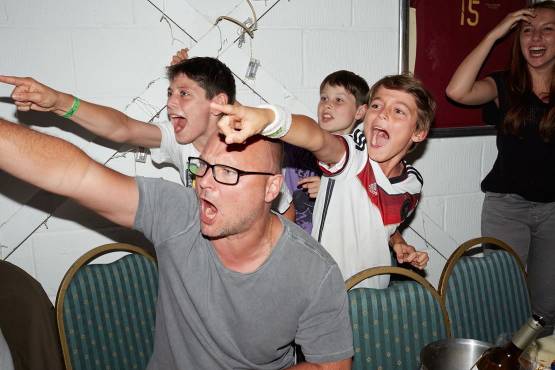 Juergen Teller and his son Ed (in the Germany football shirt) watch the 2014 World Cup final match between Germany and Argentina.