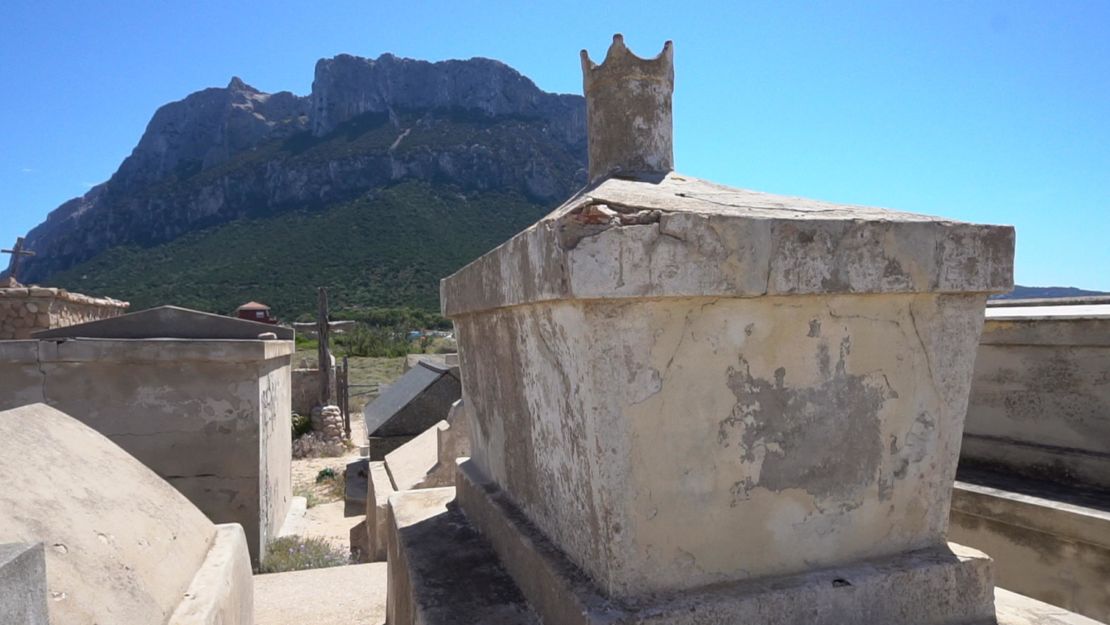 Paolo Bartoleoni's tombstone, topped with a stone crown, looks up at the towering peak of his kingdom.