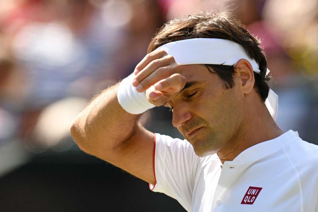 Roger Federer puts his hand to his brow.