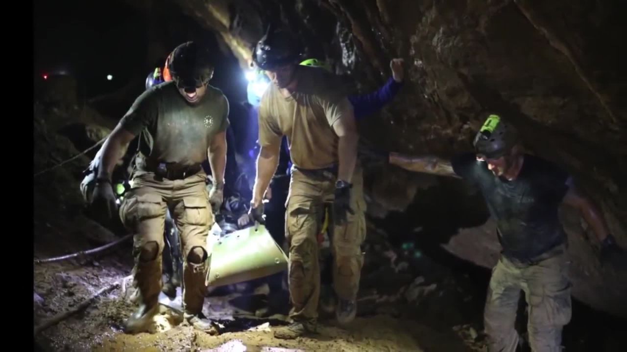 Rescuers carry one of the boys out of the cave.