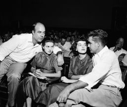 In this 1955 photo. J.W. Milam, left, and Roy Bryant, right, sit with their wives in a courtroom in Sumner, Mississippi.