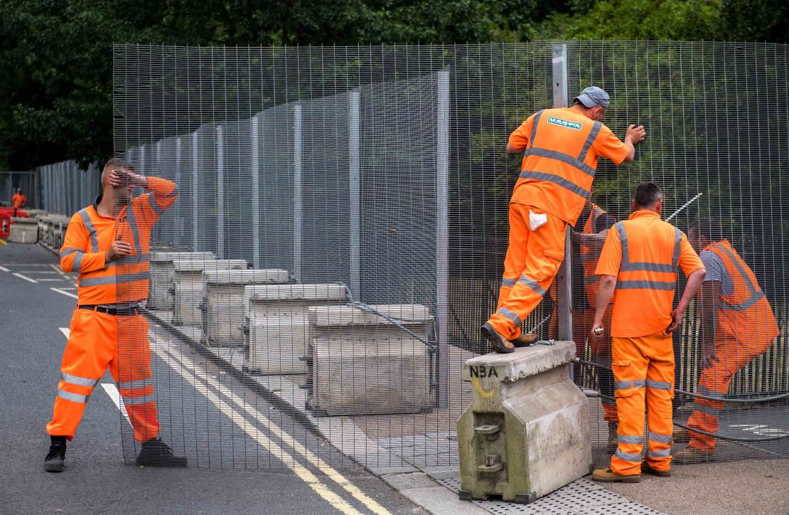 Workers install temporary security fencing outside Winfield House on Wednesday ahead of the visit of President Donald Trump.