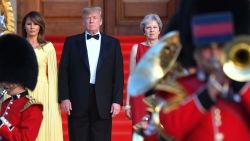 Britain's Prime Minister Theresa May (R) US President Donald Trump (C) and his wife US First Lady Melania Trump (L) stand on steps in the Great Court watching and listening to the bands of the Scots, Irish and Welsh Guards perform a ceremonial welcome as they arrive for a black-tie dinner with business leaders at Blenheim Palace, west of London, on July 12, 2018, on the first day of President Trump's visit to the UK. - The four-day trip, which will include talks with Prime Minister Theresa May, tea with Queen Elizabeth II and a private weekend in Scotland, is set to be greeted by a leftist-organised mass protest in London on Friday. (Photo by Ben STANSALL / POOL / AFP)        (Photo credit should read BEN STANSALL/AFP/Getty Images)