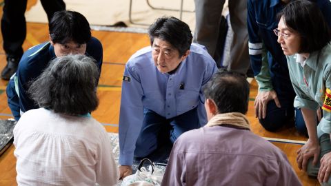 Japan's Prime Minister Shinzo Abe visits a shelter for people affected by the recent flooding in Mabi, Okayama prefecture on July 11, 2018.