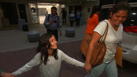 Alisson Madrid smiles as she grips the hand of her mother, Cindy, after their reunion early Friday in Houston.