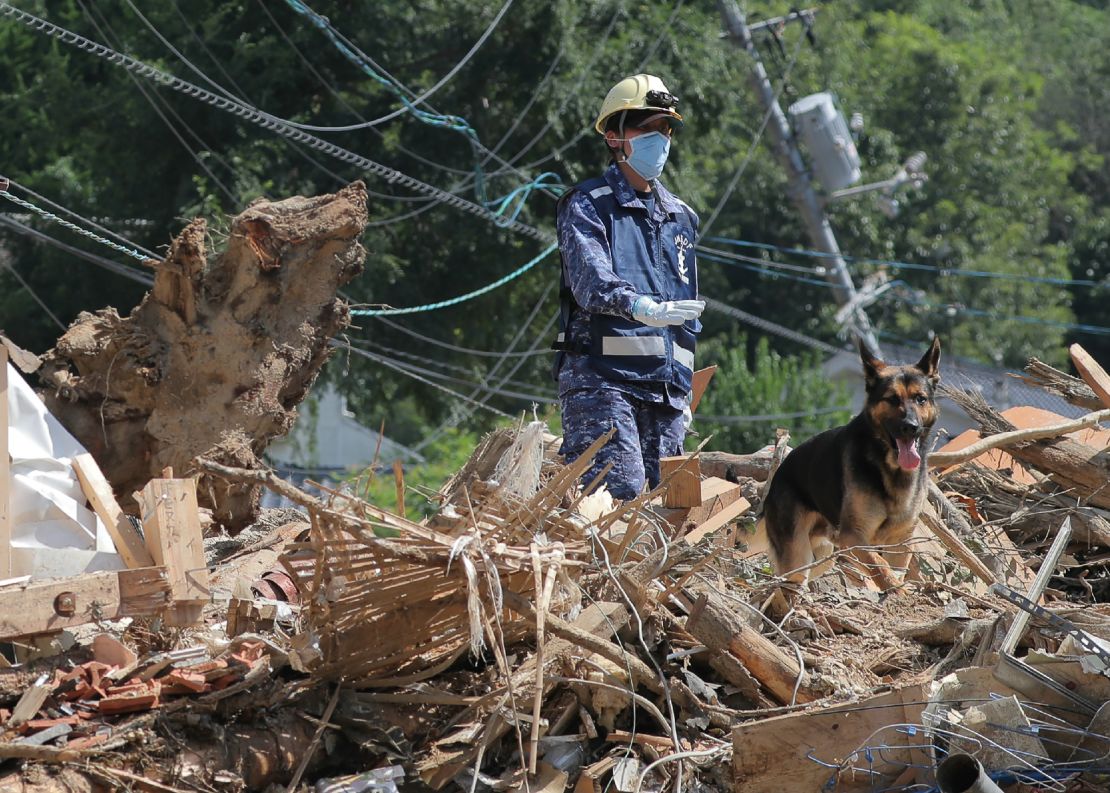 A member of Japan's Maritime Self Defense Forces searches for missing persons at a flood damage site in Kure, Hiroshima prefecture on Thursday.