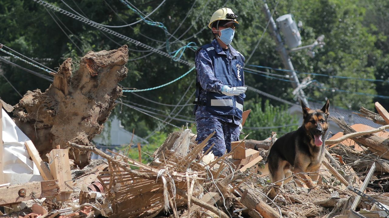 A member of Japan's Maritime Self Defense Forces searches for missing persons at a flood damage site in Kure, Hiroshima prefecture on Thursday.