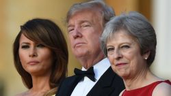 TOPSHOT - (L-R) US First Lady Melania Trump, US President Donald Trump and Britain's Prime Minister Theresa May stand on steps in the Great Court as the bands of the Scots, Irish and Welsh Guards perform a ceremonial welcome as they arrive for a black-tie dinner with business leaders at Blenheim Palace, west of London, on July 12, 2018, on the first day of President Trump's visit to the UK. - The four-day trip, which will include talks with Prime Minister Theresa May, tea with Queen Elizabeth II and a private weekend in Scotland, is set to be greeted by a leftist-organised mass protest in London on Friday. (Photo by Geoff PUGH / POOL / AFP)        (Photo credit should read GEOFF PUGH/AFP/Getty Images)