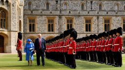 US President Donald Trump is accompanied by Britain's Queen Elizabeth II as he inspects the Guard of Honour at Windsor Castle in Windsor, west of London, on July 13, 2018 on the second day of Trump's UK visit. - US President Donald Trump on Friday played down his extraordinary attack on Britain's plans for Brexit, praising Prime Minister Theresa May and insisting bilateral relations "have never been stronger", even as tens of thousands protested in London against his visit. (Photo by Brendan Smialowski / AFP)        (Photo credit should read BRENDAN SMIALOWSKI/AFP/Getty Images)