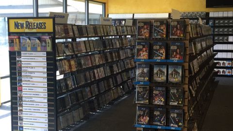 The shelves in the store are stacked with old and new movie titles.