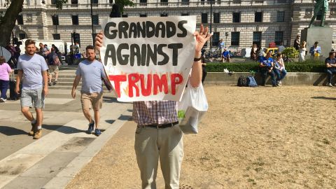 A protester holds a sign penned by hiis 16-year-old granddaughter.