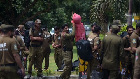 Pakistani policemen carry their gear as they arrive at the Alama Iqbal International Airport ahead of the arrival Friday of Sharif from London.