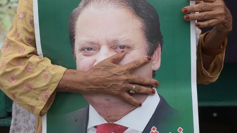 A supporter of ousted former Pakistani prime minister Nawaz Sharif holds his picture ahead of a rally led by his younger brother. 