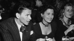circa 1940:  American singer and actor Frank Sinatra (1915-1989) sitting at a table in a nightclub next to his first wife, Nancy Barbato. Sinatra wears a striped suit, silk tie, and a 'F.D.R.' pin in his lapel.  (Photo by Hulton Archive/Getty Images)