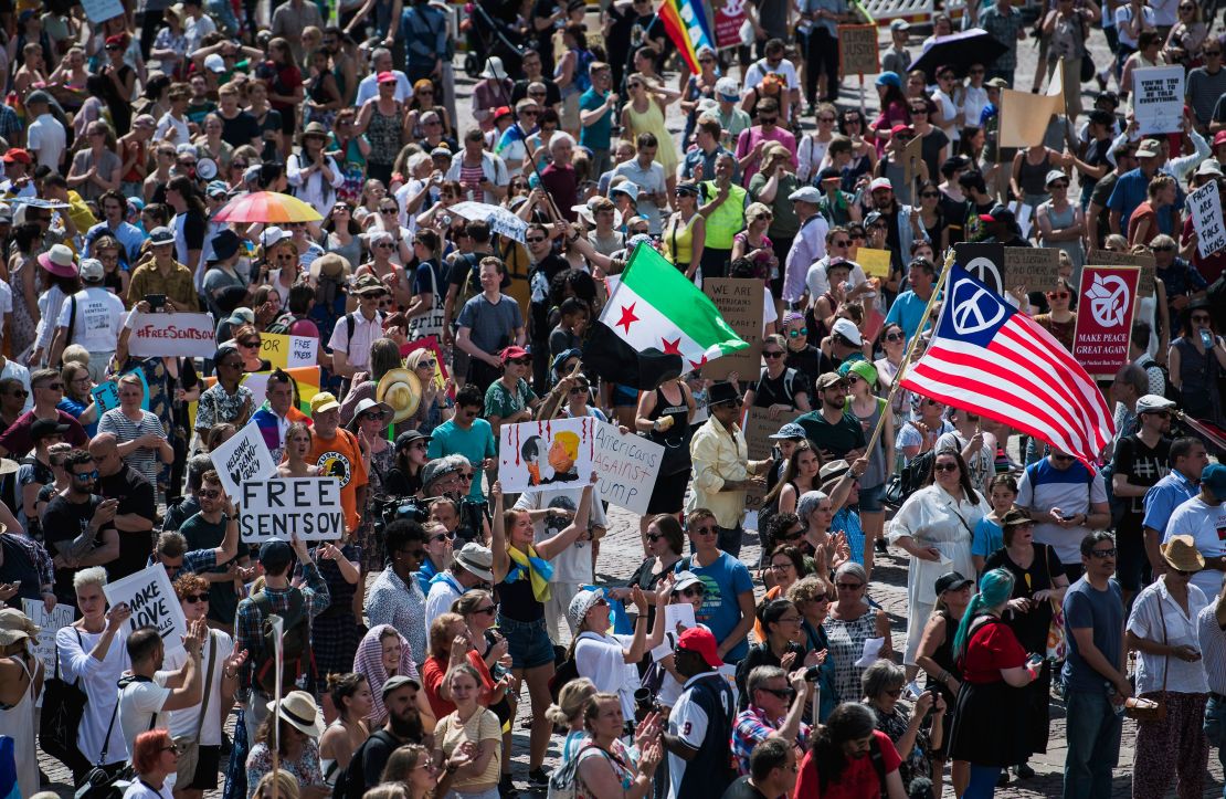 People hold placards and flags during a "Helsinki Calling" march  to defend human rights, freedom of speech and democracy on Sunday in Helsinki. 