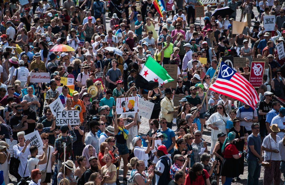 People hold placards and flags during a "Helsinki Calling" march to defend human rights, freedom of speech and democracy on Sunday in Helsinki.