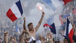 People react as they watch on the fan zone the Russia 2018 World Cup final football match between France and Croatia, on the Champ de Mars in Paris on July 15, 2018. (Photo by CHARLY TRIBALLEAU / AFP)