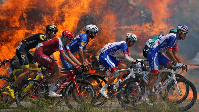 The peloton passes a fire during the Tour de France on Thursday, July 12.