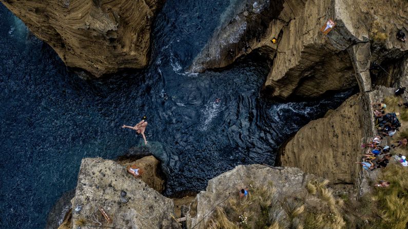 In this handout image provided by Red Bull, Viacheslav Kolesnikov dives from a 82 foot high cliff at the Snakehead on Islet Vila Franca do Campo, during the first competition day of the Red Bull Cliff Diving World Series on Friday, July 13, 2018 in Portugal.