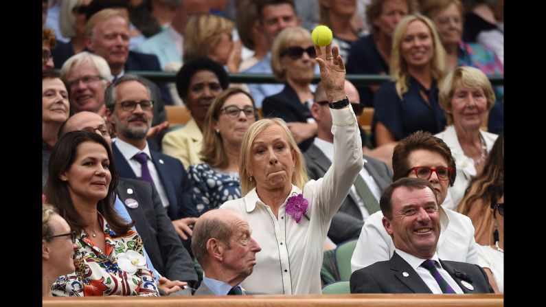 Former tennis player Martina Navratilova throws a ball back to court as Rafael Nadal plays Novak Djokovic in the men's singles semifinal match of the Wimbledon Championships on Saturday, July 14.