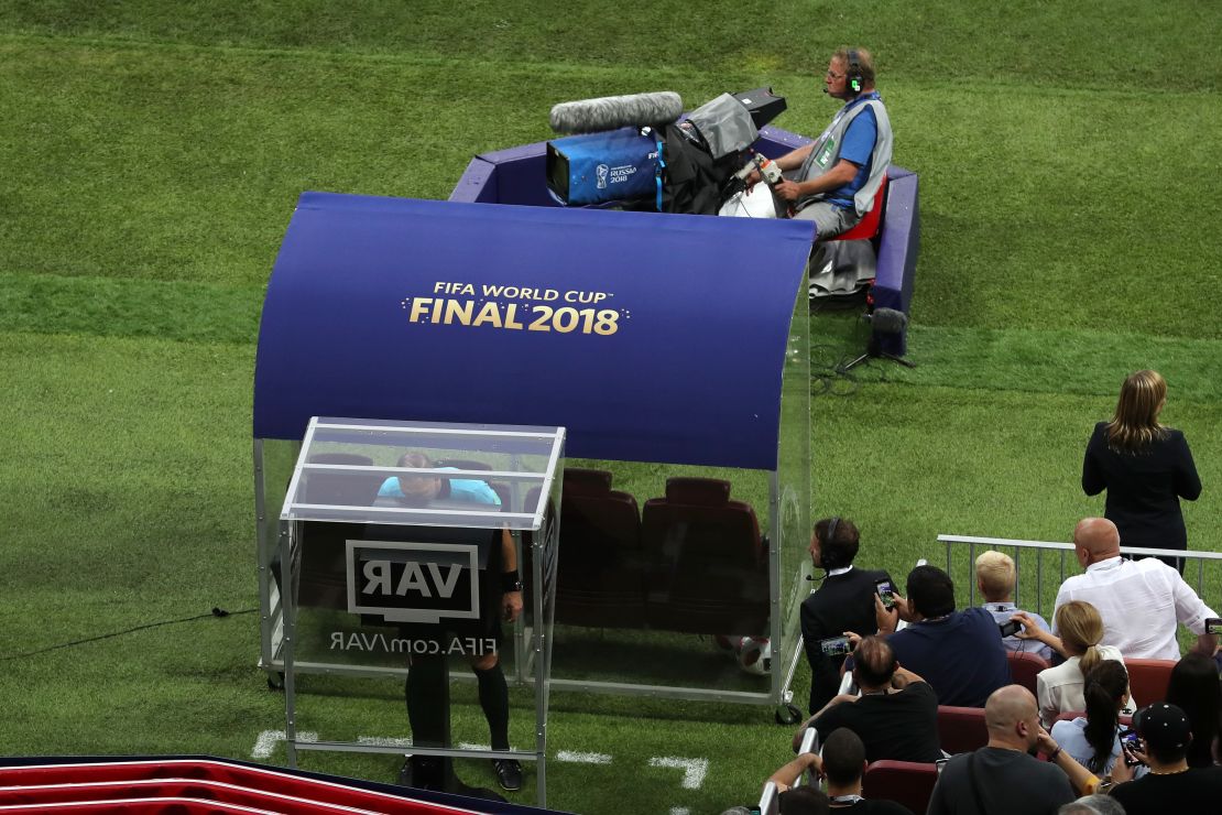 Referee Nestor Pinata reviews VAR footage before awarding France a penalty.