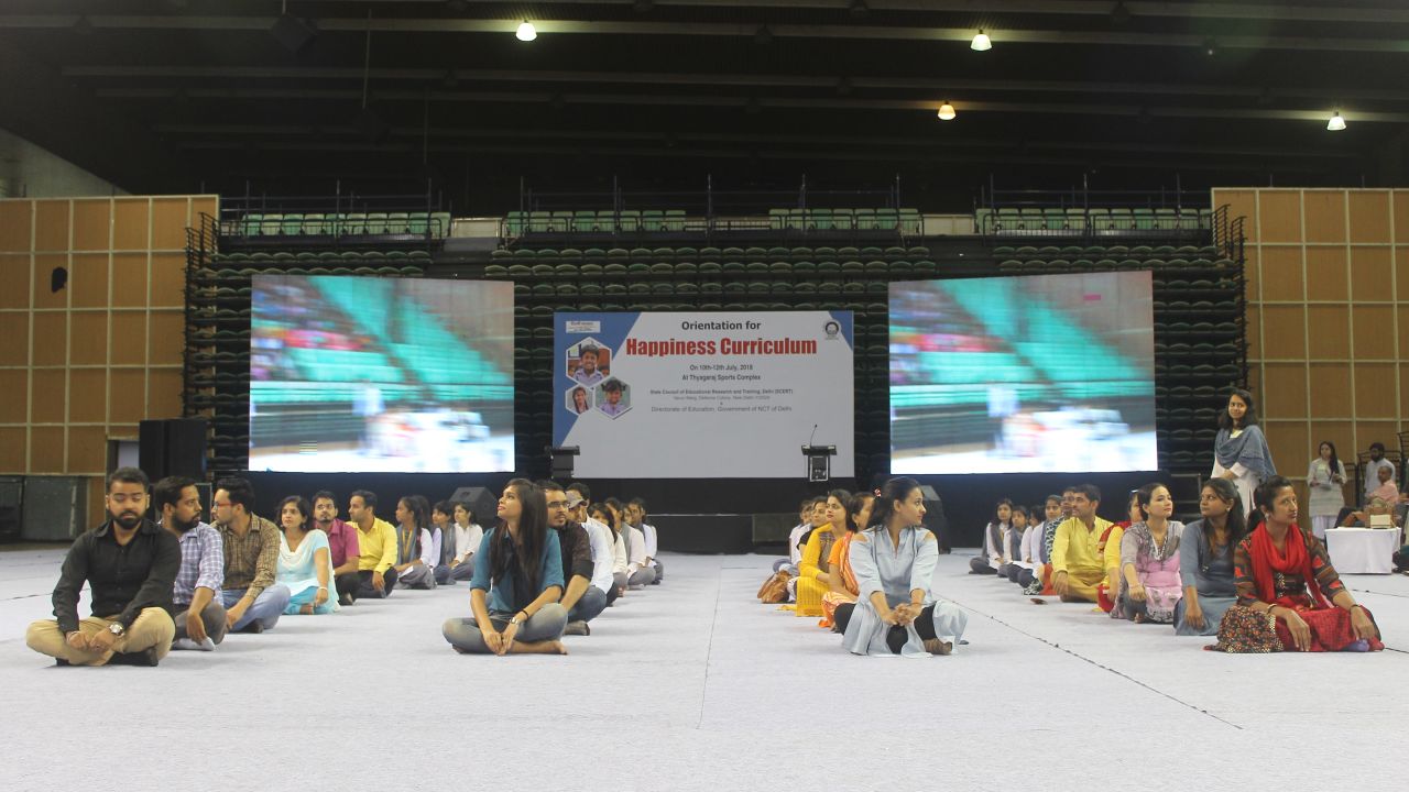Students and teachers take part in a mock classroom at the Happiness training session in New Delhi, 12 July.