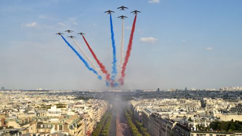 The Patrouille de France jets trail smoke in the colours of the national flag while they fly over the Champs Elysee.