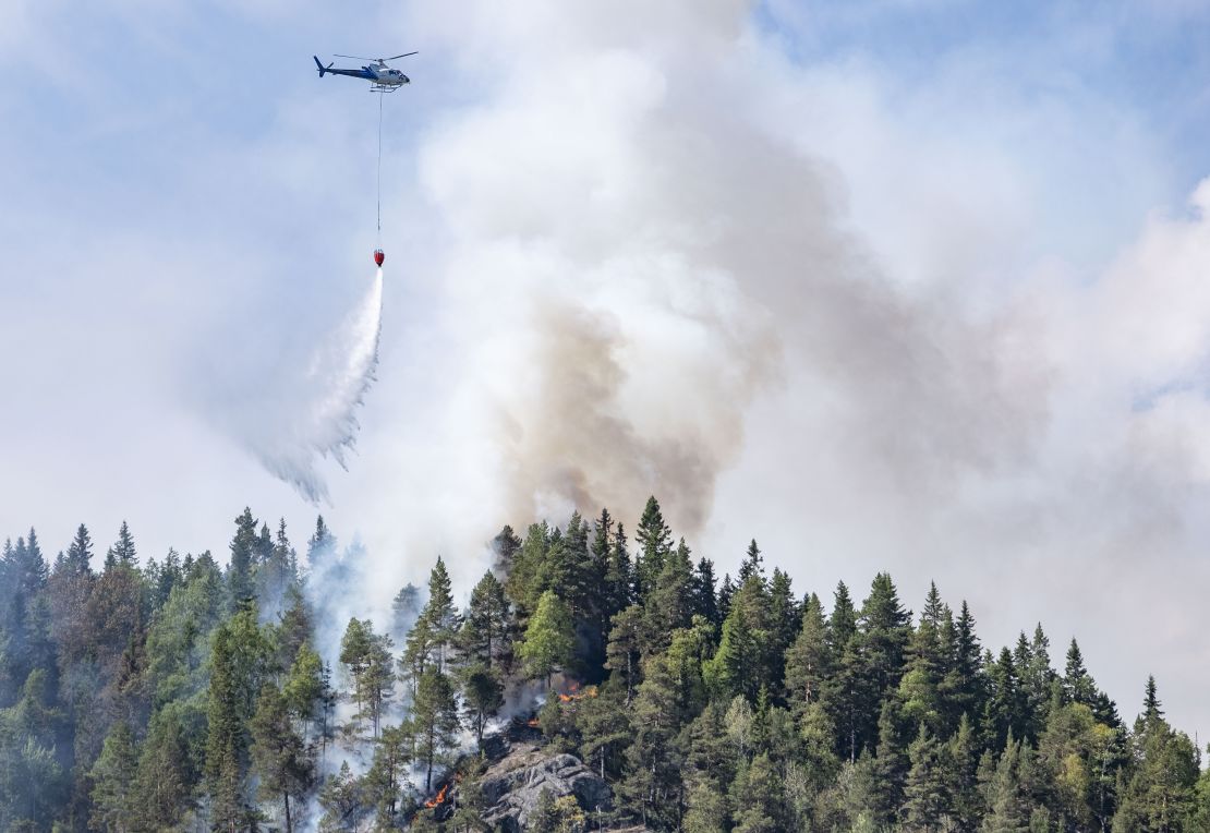 Firefighters use helicopters to fight wildfires in the southern part of Norway in Sordal on July 14.