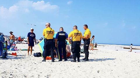 A tourist was basking on the beach when the stake of a flying umbrella went through her ankle, police said.