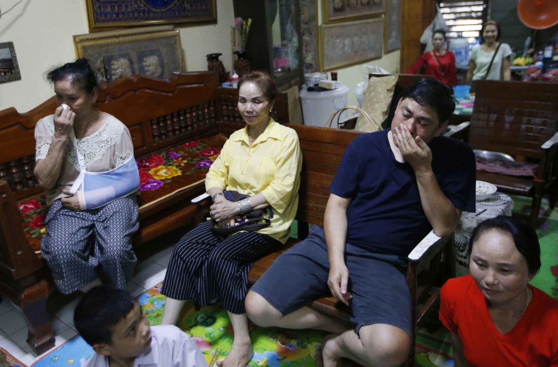 Relatives of Duangpetch Promthep, one of the rescued boys, watch the press conference live on television.