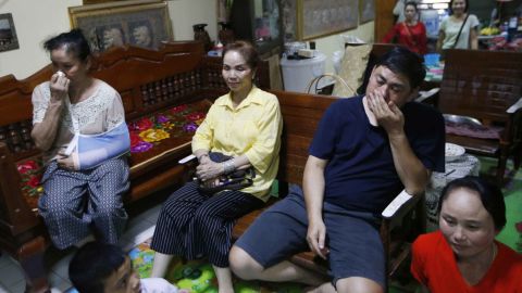 Relatives of Duangpetch Promthep, one of the rescued boys, watch the press conference live on television.