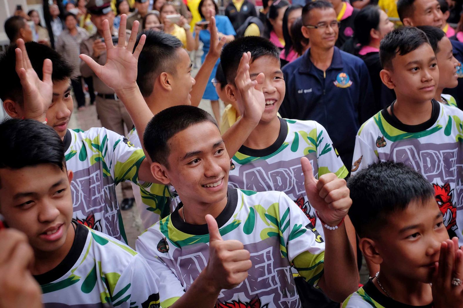 Members of the soccer team greet well-wishers as they arrive for the news conference on July 18.