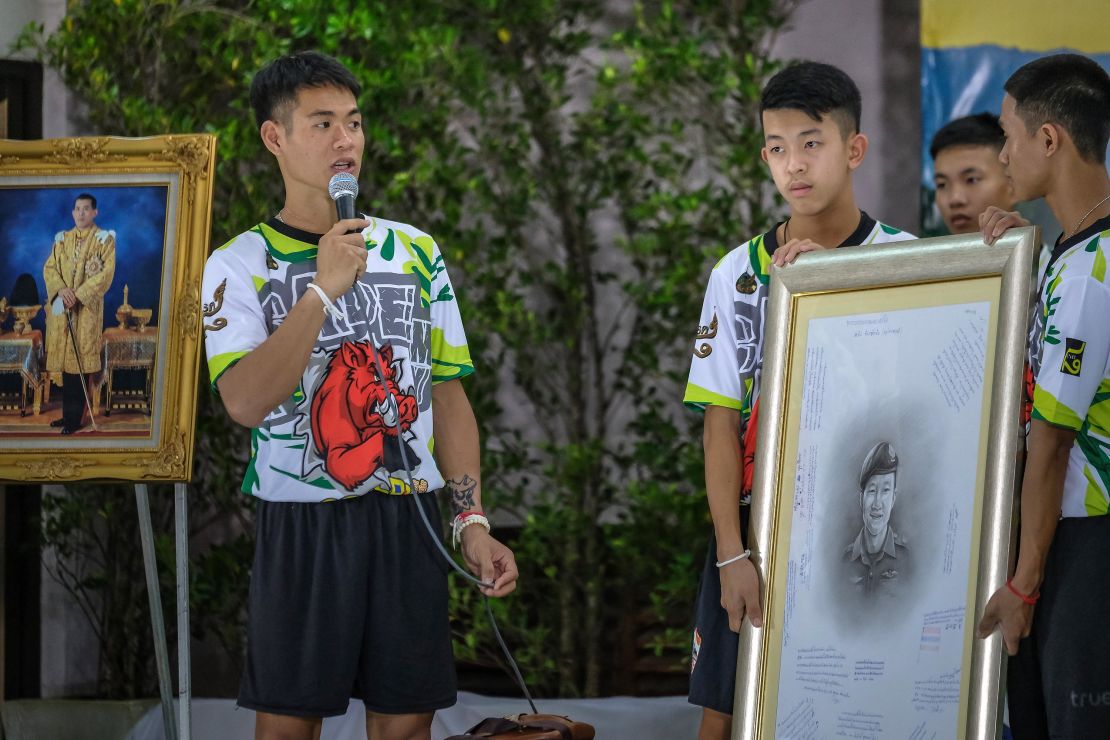 Coach Ekkapol Chantawong, left, pays tribute to Saman Kunan, the Thai Navy SEAL who died during the resuce attempt.