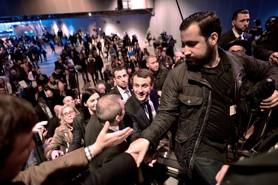 Emmanuel Macron, centre, shakes hands as he visits Paris' international agriculture fair in March 2017 as his head of security Alexandre Benalla, right, clears the way.