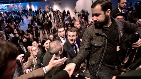 Emmanuel Macron, centre, shakes hands as he visits Paris' international agriculture fair in March 2017 as his head of security Alexandre Benalla, right, clears the way.