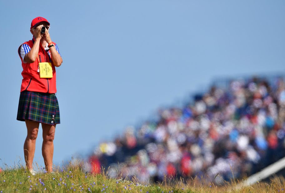 A course marshal uses a rangefinder during first-round play.