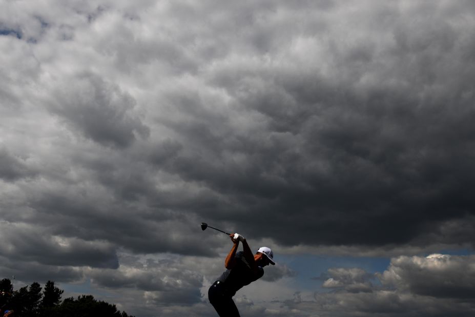 Dustin Johnson plays his tee shot on the ninth hole Thursday. The dark clouds symbolized his tough first round (5-over). He ended up missing the cut.
