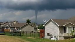 A tornado destroying a home, a tornado above a man's home and a third tornado to the left in Bondurant, IA.