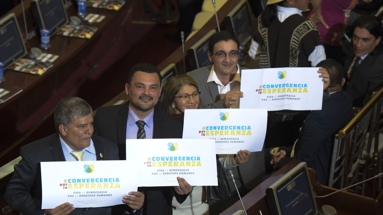 Members of FARC hold placards reading "convergence for hope" at the capitol in Bogota, Colombia, during the installation of the new Congress.