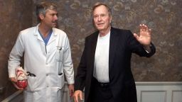 Former President George Bush, center, waves as he leaves with cardiologist Mark Hausknecht, left, and Bush's family doctor Ben Orman, right, after a news conference at Methodist Hospital Friday, Feb. 25, 2000 in Houston. Bush spent Thursday night in a Florida hospital and was released Friday after being treated for atrial fibrillation. He returned to Houston Friday and was admitted to Methodist Hospital for further tests. (AP Photo/David J. Phillip)