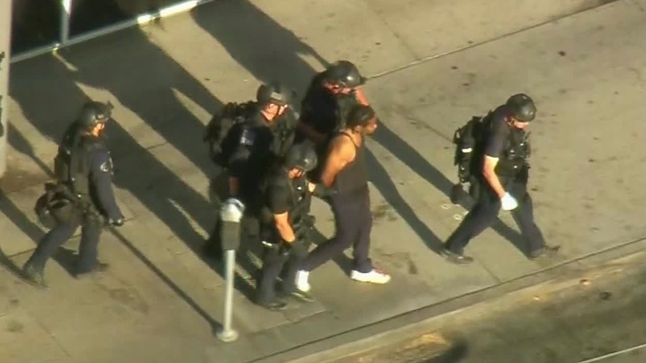 Aerial footage shows police leading the suspect away in handcuffs Saturday after the standoff.
