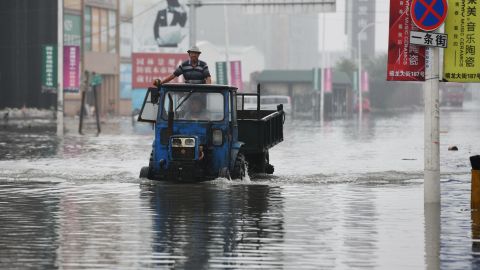 A local drives through a flooded street caused by heavy rainstorms in Harbin city, northeast China's Heilongjiang province on July 19.
