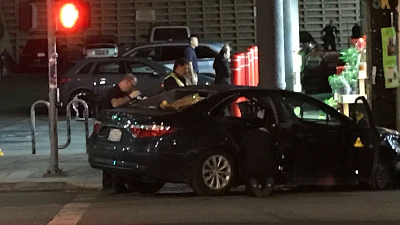 Police search the suspect's vehicle early Sunday morning after the standoff.