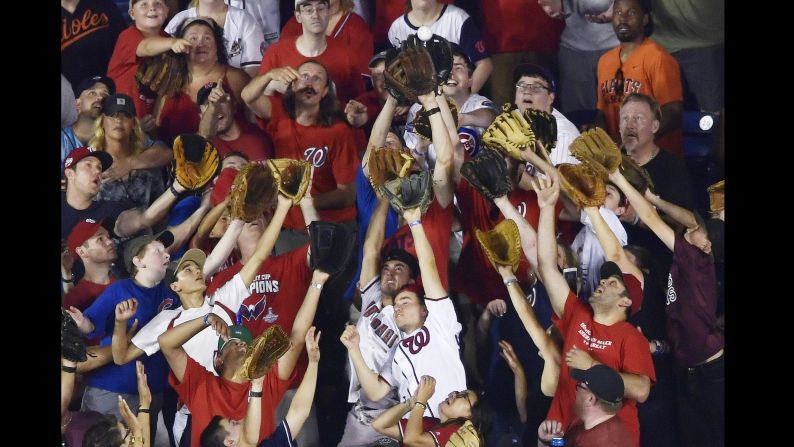 Fans reach for a ball during the Major League Baseball Home Run Derby on Monday, July 16.