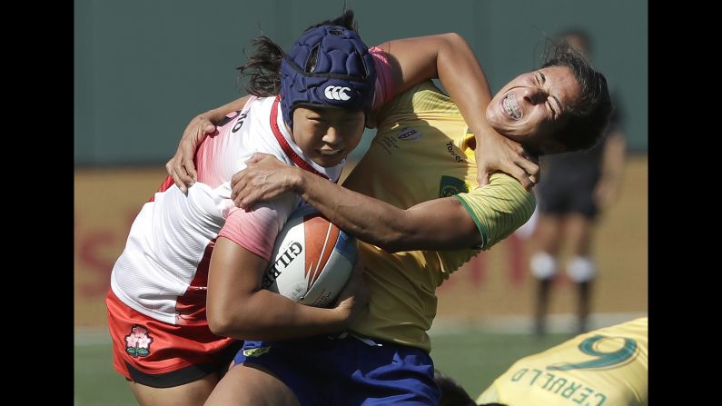 Japan's Noriko Taniguchi, left, breaks a tackle from Brazil's Amanda Araujo during a Rugby World Cup Sevens match on Friday, July 20.