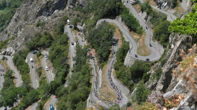 Cyclists climb a winding mountain road during the 12th stage of the Tour de France on Thursday, July 19.